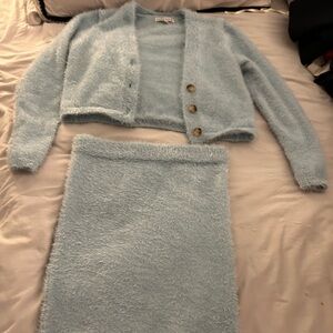 It’s a 3 piece baby blue warm set. Sweater, crop top and skit.